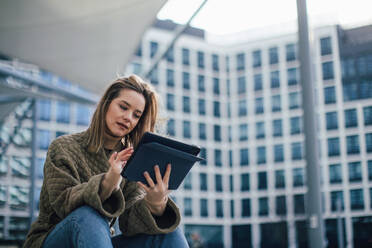 Portrait of young fashionable woman in city with digital tablet. - HPIF32277