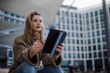 Portrait of young fashionable woman in city with digital tablet. - HPIF32278