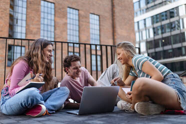 Eine Gruppe von Studenten der Generation Z, die nach einer Vorlesung auf dem Campus zusammen lernen. Junge stylische Zoomer arbeiten gemeinsam an einem Schulprojekt und bereiten eine Präsentation vor. Das Konzept der Macht der Freundschaft und die Bedeutung der Bildung der Generation Z. - HPIF32296