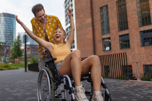 Schönes lächelndes Gen Z-Mädchen im Rollstuhl mit ihrem Freund. Inklusion, Gleichheit und Vielfalt in der Generation Z. - HPIF32308