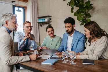 Young colleagues having casual discussion during meeting in office. Group of men and women sitting in conference room. Company workshop. - HPIF32323