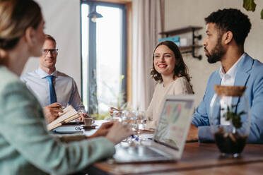 Young colleagues having casual discussion during meeting in office. Group of men and women sitting in conference room. Company workshop. - HPIF32326