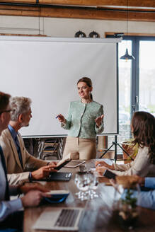 Female CEO manager leading corporate meeting in office. Businesswoman in meeting with colleagues in conference room. - HPIF32327