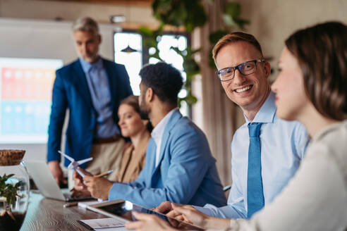 Corporate business team and manager in meeting, discussing renewable energy options for business. Group of men and women sitting in conference room. - HPIF32366