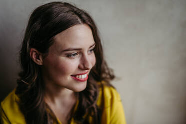 Young woman smiling looking aside studio portrait on gray copy space. Close-up portrait of a charismatic businesswoman, manager, ceo, lawyer. - HPIF32381