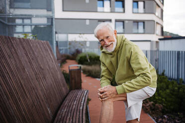 Älterer Mann beim Sport in der Stadt: Ein älterer, vitaler Mann führt einen aktiven Lebensstil und geht jeden Tag joggen. - HPIF32408