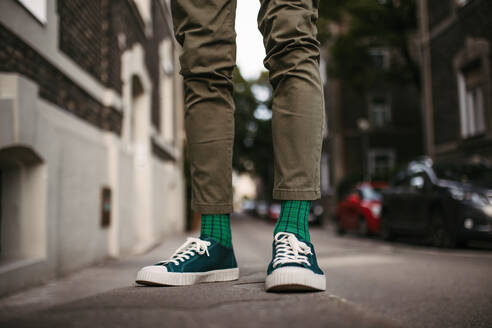 Close-up of a man's stylish shoes and quirky socks standing on the street in the city. - HPIF32435