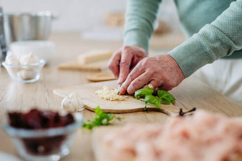 Close up of senior man cutting a garlic. - HPIF32459