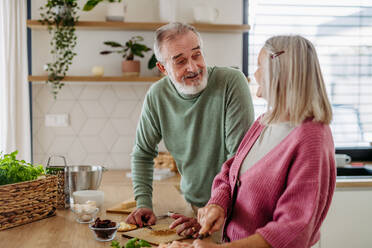 Senior couple cooking together in the kitchen. - HPIF32462