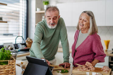 Senior couple cooking together in the kitchen. - HPIF32463