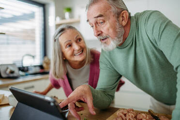 Senior couple cooking together in the kitchen. - HPIF32466