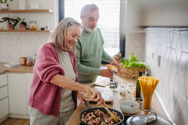 Senior couple cooking together in the kitchen. - HPIF32470