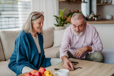 Senior couple playing dominoes game at home. - HPIF32505