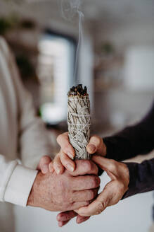 Close up of senior couple doing ritual with a sage. - HPIF32518