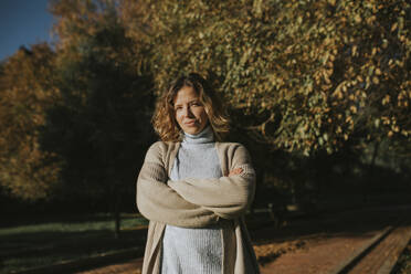 Frau mit verschränkten Armen im Herbstpark stehend - DMGF01148