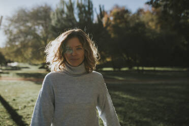 Lächelnde Frau in grauem Pullover im Herbstpark - DMGF01150