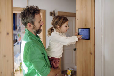 Tochter lernt mit Vater, die Hausautomatisierungs-App auf dem Tablet-PC einzustellen - HAPF03520