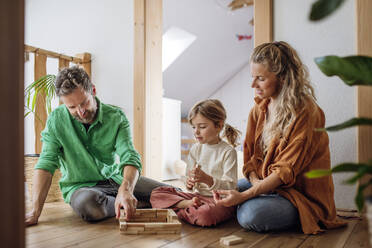 Tochter spielt Blockspiel mit Eltern zu Hause - HAPF03524