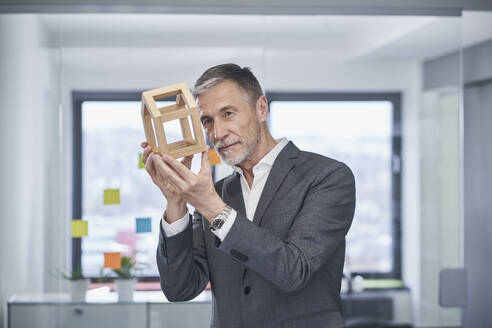 Immobilienmakler begutachtet Modellhaus im Büro - RORF03609