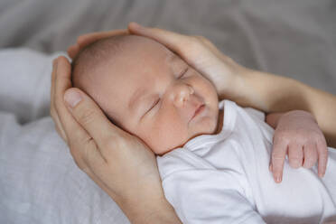 Newborn baby boy sleeping in hands of mother - NDEF01466