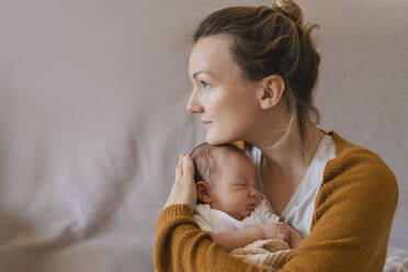 Mother embracing baby boy in arms at home - NDEF01485