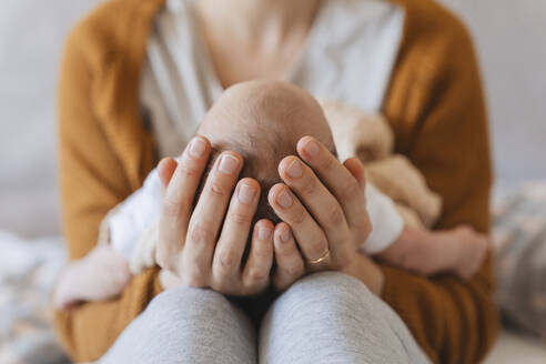 Mother holding newborn son in hands at home - NDEF01487