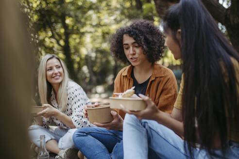 Freiwillige Helfer bei einem Gemeinschaftsprojekt essen gemeinsam im Gemeinschaftsgarten - HAPF03626