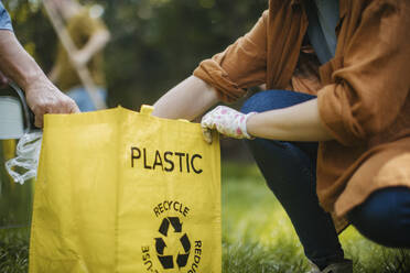 Frau legt Plastikmüll-Recycling-Sack in die Wohnung - HAPF03695