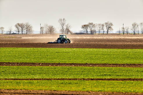 Traktor pflügt Feld im zeitigen Frühjahr - NOF00832