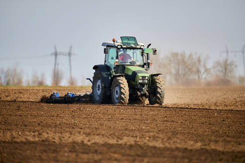 Traktor pflügt Feld im zeitigen Frühjahr - NOF00833