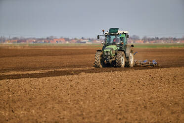 Traktor pflügt Feld im zeitigen Frühjahr - NOF00836