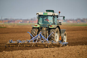 Traktor pflügt Feld im zeitigen Frühjahr - NOF00838