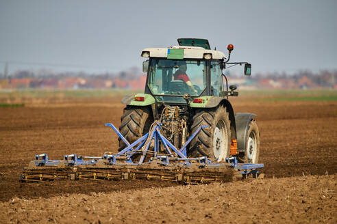 Traktor pflügt Feld im zeitigen Frühjahr - NOF00838