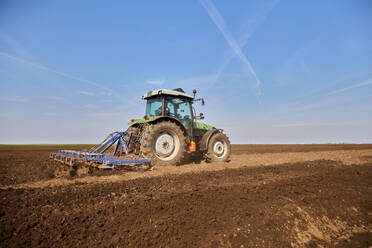 Traktor pflügt Feld im zeitigen Frühjahr - NOF00839