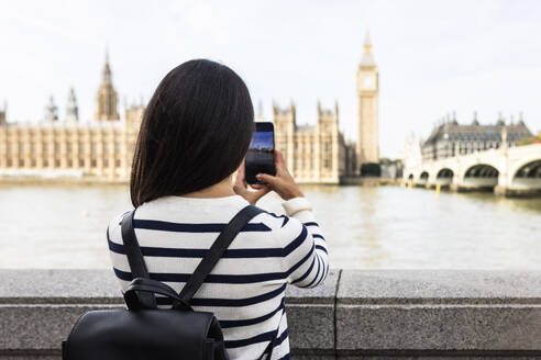 Frau fotografiert Big Ben und Houses of Parliament mit ihrem Smartphone in London - WPEF07954