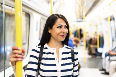 Smiling woman traveling in subway - WPEF07969