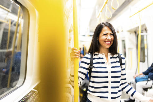 Happy woman traveling in subway - WPEF07971