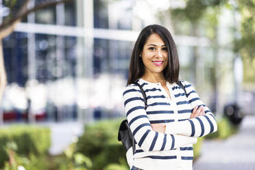 Smiling woman standing with arms crossed - WPEF07992