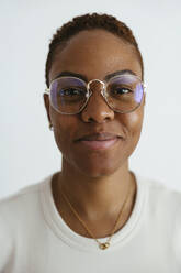 Smiling woman wearing eyeglasses against white background - EBSF04144