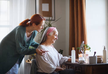 Caregiver helping her senior client with a make up. - HPIF32539