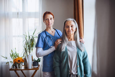 Portrait of senior caregiver and senior woman in her home. - HPIF32540