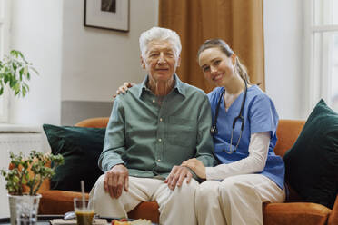 Young nurse taking care of elderly senior in his home. - HPIF32605