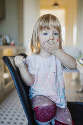 Porträt eines kleinen Mädchens mit unordentlichen, mit Farbe befleckten Händen. Müdes Kind, das nach einer Bastelarbeit gähnt. - HPIF32719