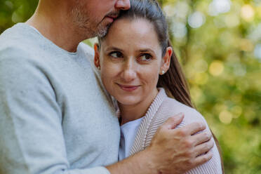 Portrait of happy couple in love,standing in a forest. - HPIF32741