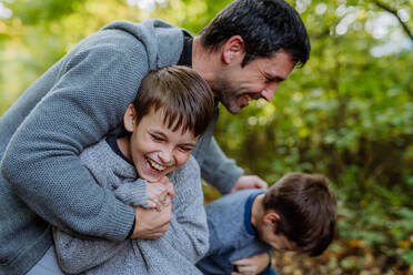 Father having fun with his sons in a forest. - HPIF32758