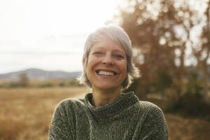 Glückliche Frau mit grauem Haar auf einem Feld - EBSF04177