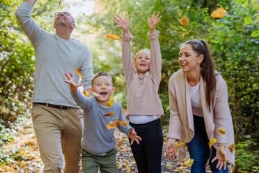 Happy family having fun with foliage in autumn forest. - HPIF32777