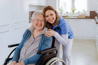 Portrait of nurse and her senior client on a wheelchair. - HPIF32826