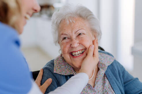 Nahaufnahme einer Krankenschwester, die die Wange einer älteren Frau streichelt. - HPIF32828