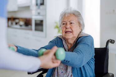 Krankenschwester übt mit einer älteren Frau in ihrem Haus, Konzept der Gesundheitsfürsorge und Rehabilitation. - HPIF32861